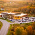 Vue miniature façon tilt-shift d'un casino moderne et bas et de son stationnement, parmi des champs d'automne en bordure d'une petite ville
